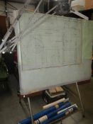 An Engineer's draught board on stand with some engineering drawings and mechanical engineering