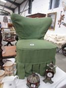 A small green fabric covered chair.