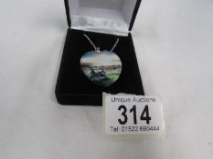 A Danbury Mint white metal pendant with seashore scene and poem on back.