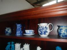 A quantity of blue and white jugs and a blue and white cup and saucer.