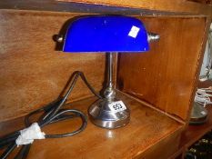A small bankers lamp with blue glass shade.