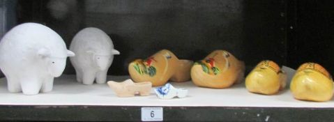 A shelf of miscellaneous items including wooden clogs, figures of sheep etc.