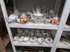 2 shelves of assorted teapots, milk jugs, sugar bowls etc and 5 Aynsley commemorative bowls.