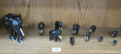 A set of 11 granduated ebony and bone elephants.