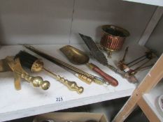 A shelf of brass fire implements etc.