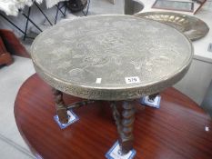 An Indian brass topped table with barley twist stand.