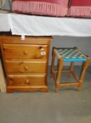 A 3 drawer bedside chest and a stool.