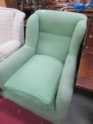 A green fabric covered arm chair.