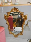 An ornate gilt framed mirror.