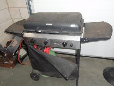 A gas barbecue on trolley base with gas cylinder.