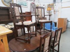 An oval oak extending dining table, 2 carvers and 4 dining chairs.