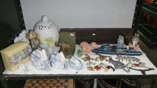 A shelf of animal figures including coat hooks, brass frogs etc.