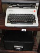 A cased olympia monica typewriter (needs ink).