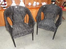 2 black wicker chairs.