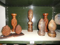 7 carved wooden items including a pair of candlesticks, pair of pine cones etc.