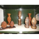 7 carved wooden items including a pair of candlesticks, pair of pine cones etc.