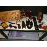 An assortment of ornamental wooden items including masks, figures, tray, paper knife etc.