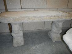 A timber seat on log plinths.