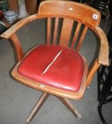 An Edwardian oak swivel office chair.