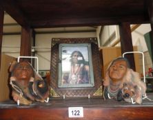 2 american indian wall plaques and a picture.