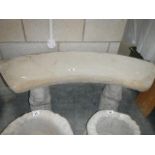 A curved stone seat on squirrel plinths.