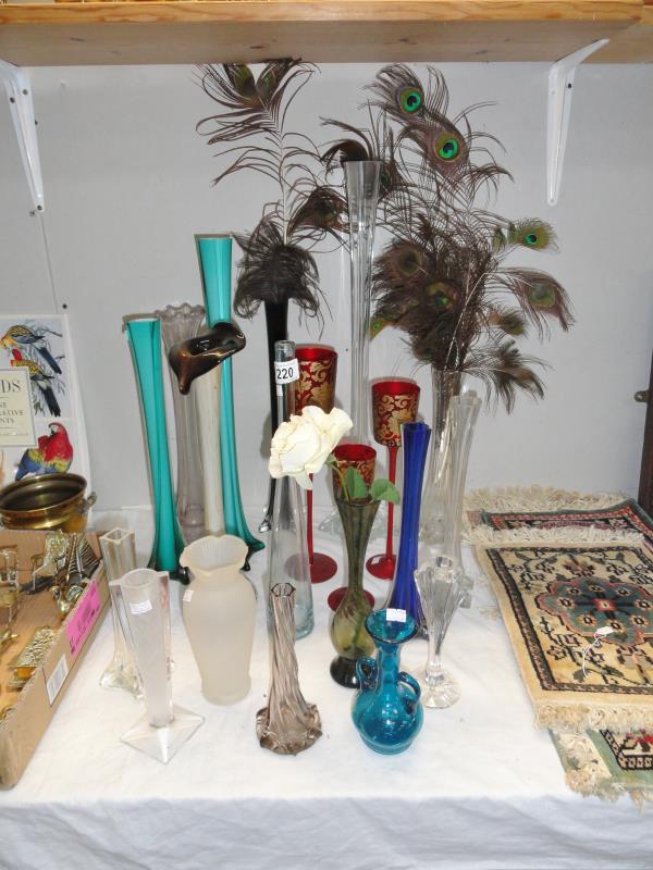 A quantity of posy vases, including peacock feathers.