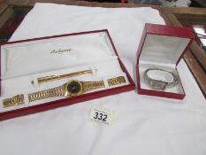 A wristwatch with pen set and another wrist watch.