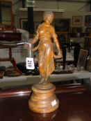 A metal figure of a lady with plaque to base 'Modistie'.