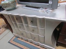A silver coloured 3 drawer chest.