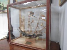 A cased model of a galleon with plaque dated 1938.