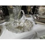 An ornate silver plate basket and a ladle.
