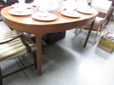An oval teak dining table.