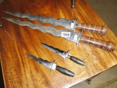 A pair of wavy blade short swords and a pair of wavy blade knives.