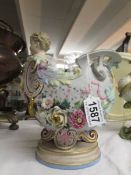 An unusual continental porcelain vase in a shell shape with cherub on front and mask on rear,