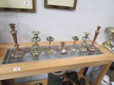 2 pairs of brass candlesticks, a pair of copper candlesticks and a brass chamber stick.