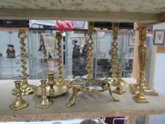 A mixed lot of brass candlesticks including barley twist and a trivet.