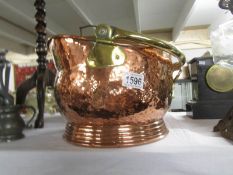 A polished copper coal scuttle.