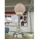 An art deco chrome barley twist lamp with pink shade.