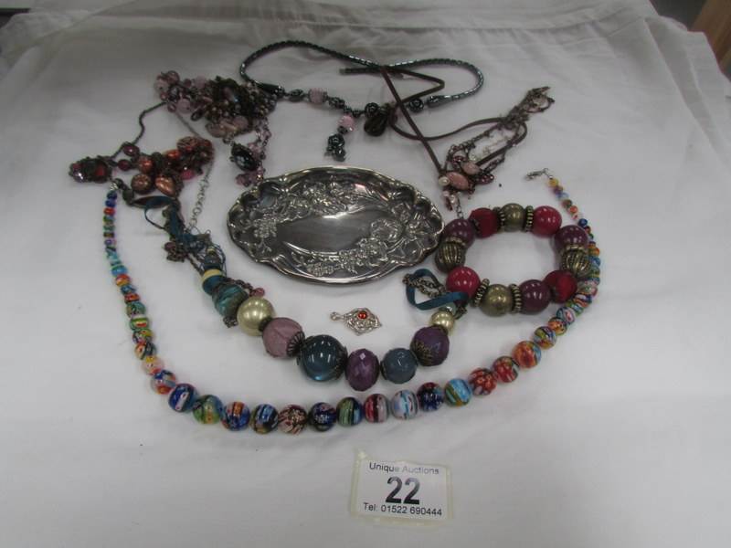 A mixed lot of necklaces, bracelets etc and an embosses white metal tray.