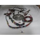 A mixed lot of necklaces, bracelets etc and an embosses white metal tray.