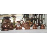 A set of 5 graduated copper measures.