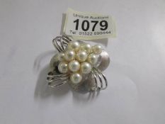 A circa 1970's cultured pearl and textured silver spray brooch set with eleven pearls in an