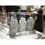 A silver plate 3 bottle tantalus complete with decanters,.