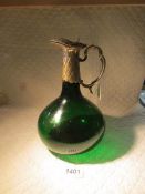 A green glass claret jug with silver plated top.