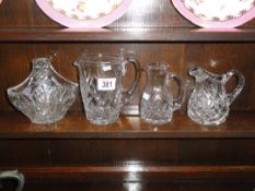 3 cut glass jugs and a cut glass basket.