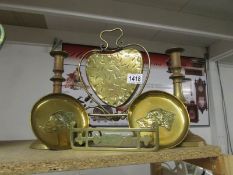 A brass heart shaped dinner gong, a pair of brass candlesticks,