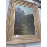 A gilt framed oil painting of a river scene signed Adams.