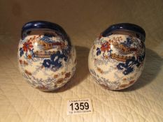 A pair of early 20th century Imari pattern vases with offset handles, marked England.