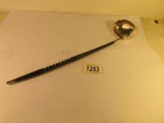 A late Victorian silver ladle with ebony handle.