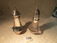 A hall marked silver sugar sifter and a glass example with silver top.